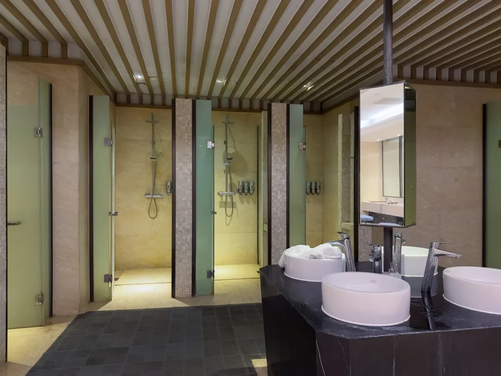 Row of individual cold water shower cubicles in a commercial facility
