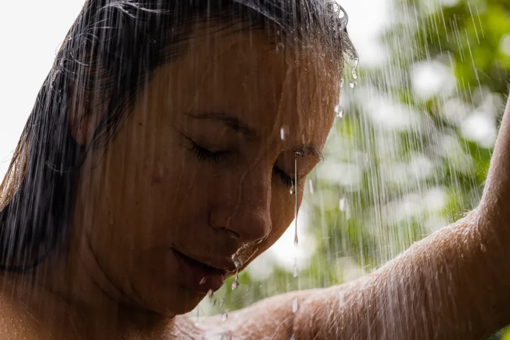 Woman enjoying a cold water shower outdoors